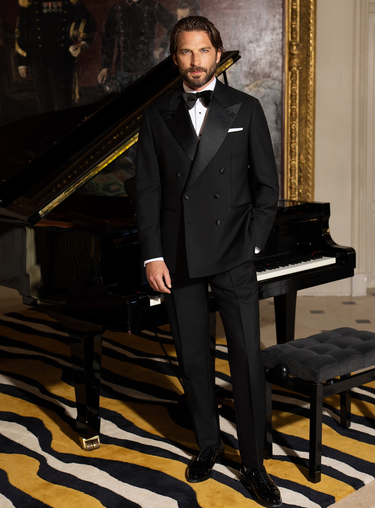 Black Consiglieri tuxedo with lustrous lapels, a white shirt and black bow tie