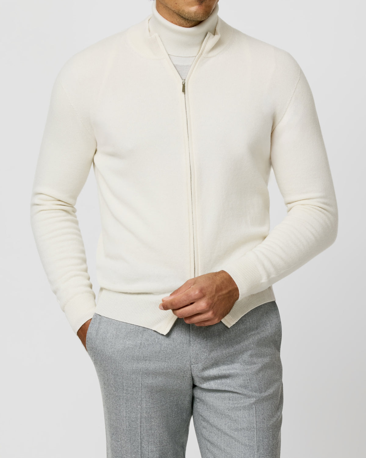 Cream Consiglieri zip cardigan with a stand collar, worn with grey trousers