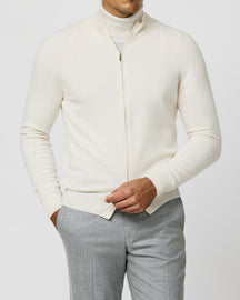 Cream Consiglieri zip cardigan with a stand collar, worn with grey trousers