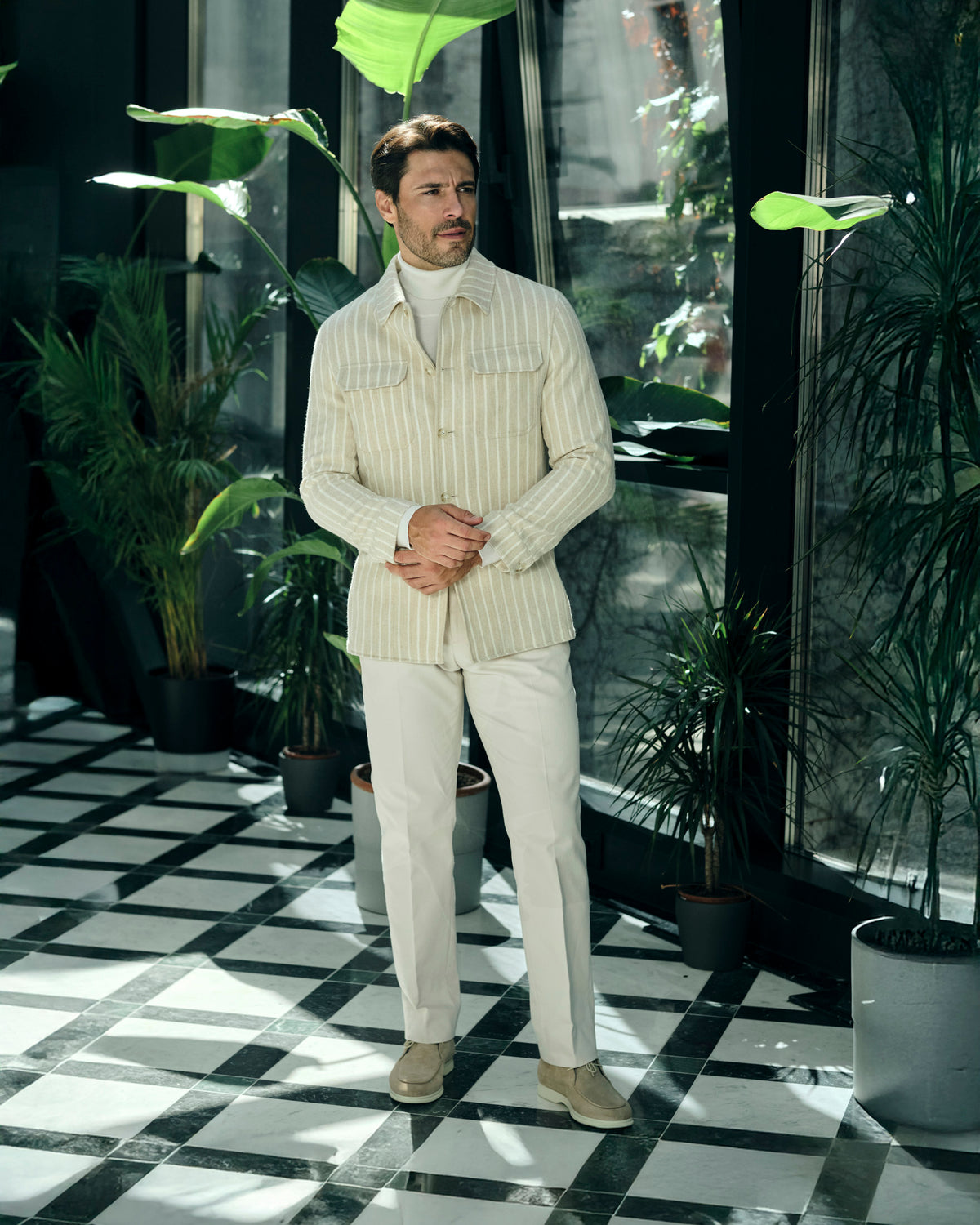 Cream pinstriped Consiglieri jacket with a cream turtleneck and trousers