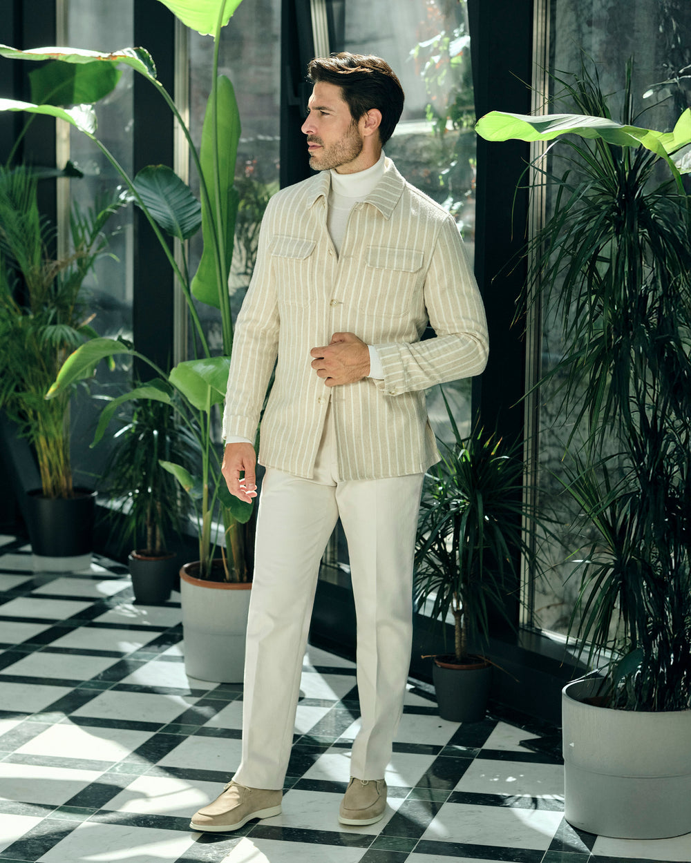 Cream pinstriped Consiglieri jacket with a cream turtleneck and trousers