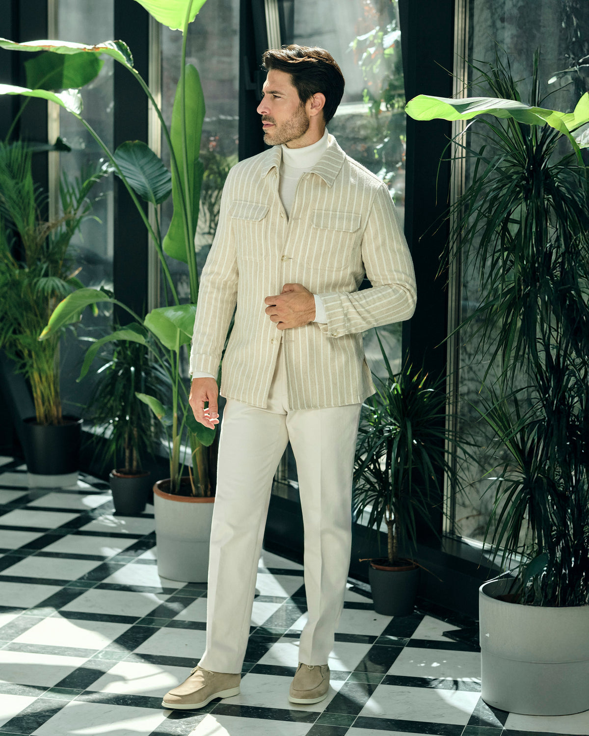 Cream pinstriped Consiglieri jacket with a cream turtleneck and trousers