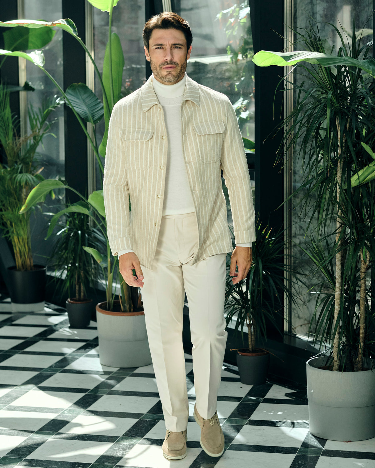 Cream pinstriped Consiglieri jacket with a cream turtleneck and trousers