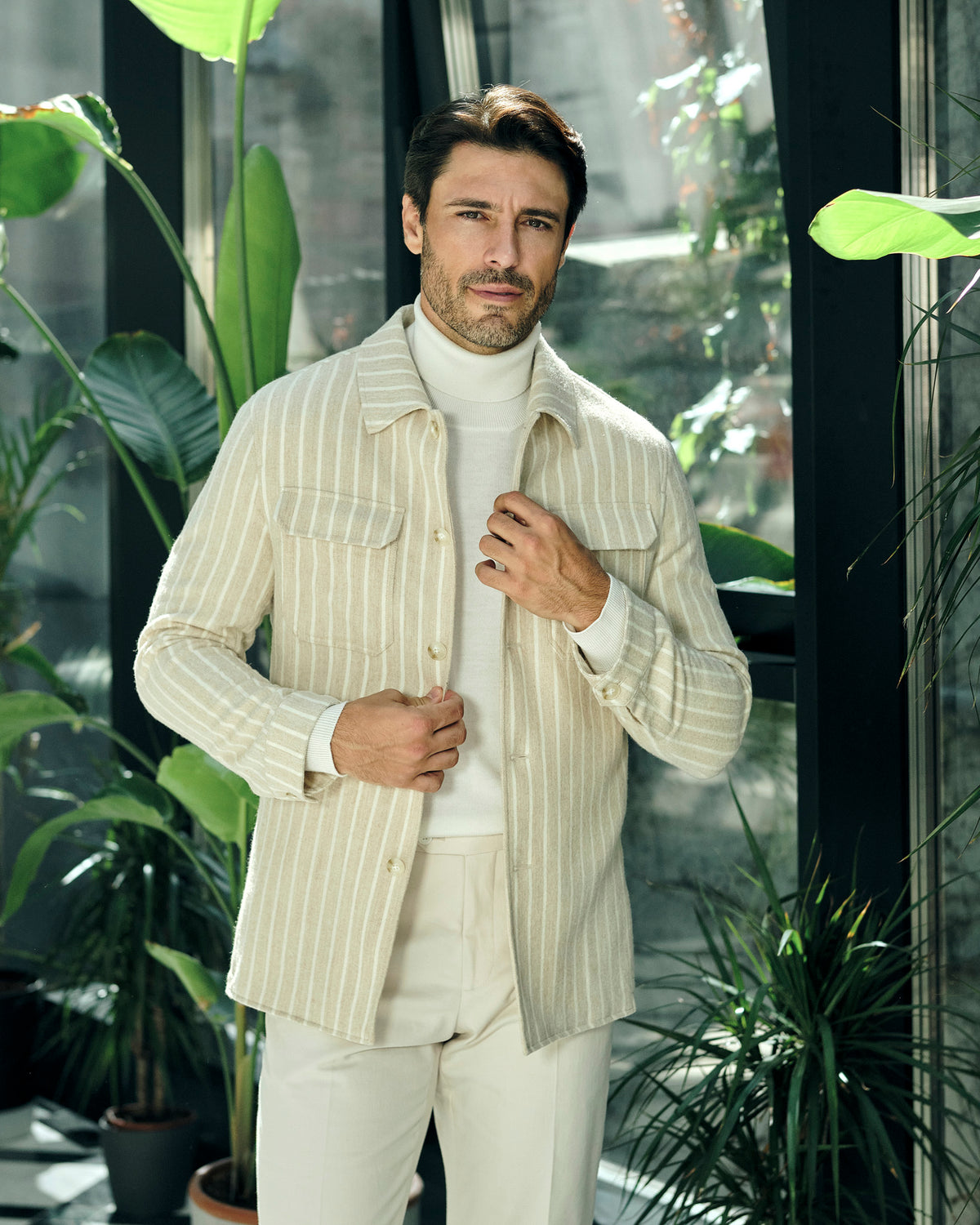 Cream pinstriped Consiglieri jacket with a cream turtleneck and trousers