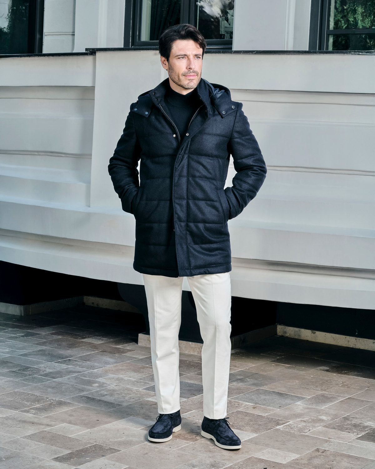 Black quilted Consiglieri hooded jacket worn with cream trousers