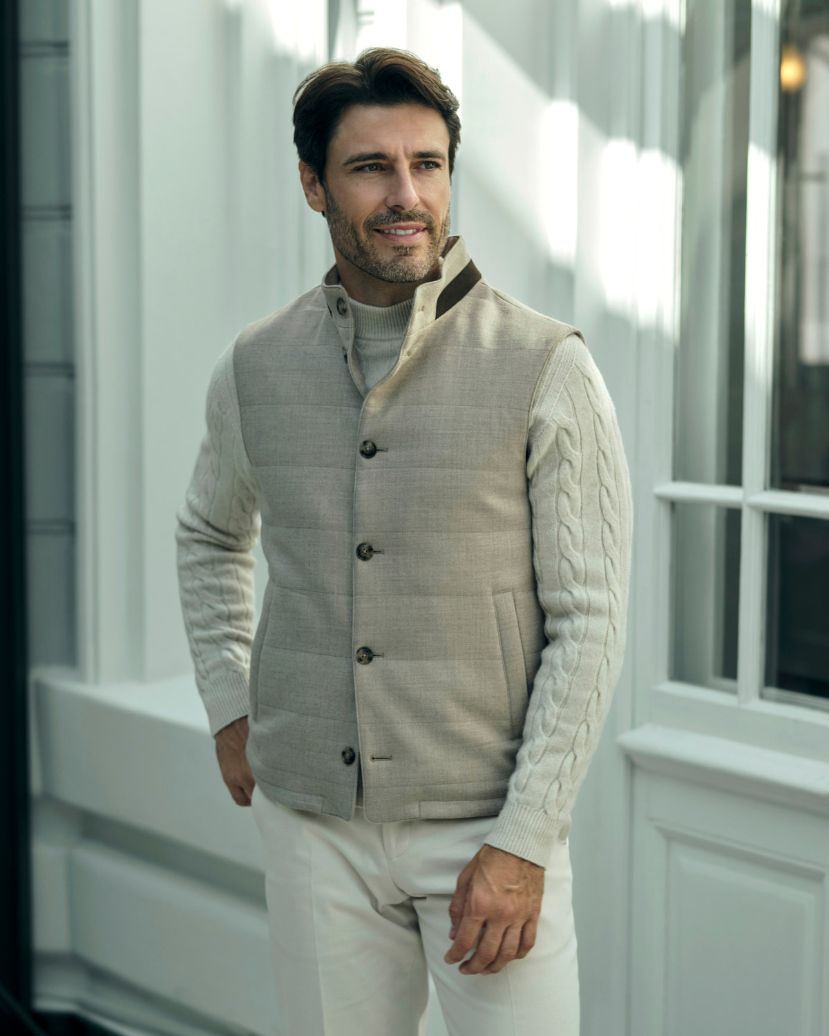 Beige quilted Consiglieri gilet with buttons over a cream cable-knit sweater