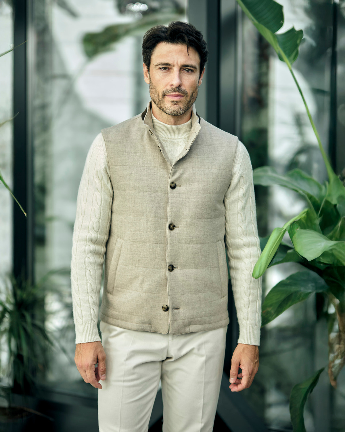 Beige quilted Consiglieri gilet with buttons over a cream cable-knit sweater