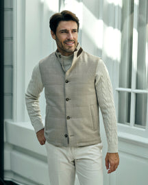 Beige quilted Consiglieri gilet with buttons over a cream cable-knit sweater