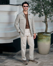 Light beige Consiglieri jacket with flap pockets, a brown sweater and white trousers