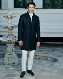 Black Consiglieri coat with a shirt collar, worn with white trousers