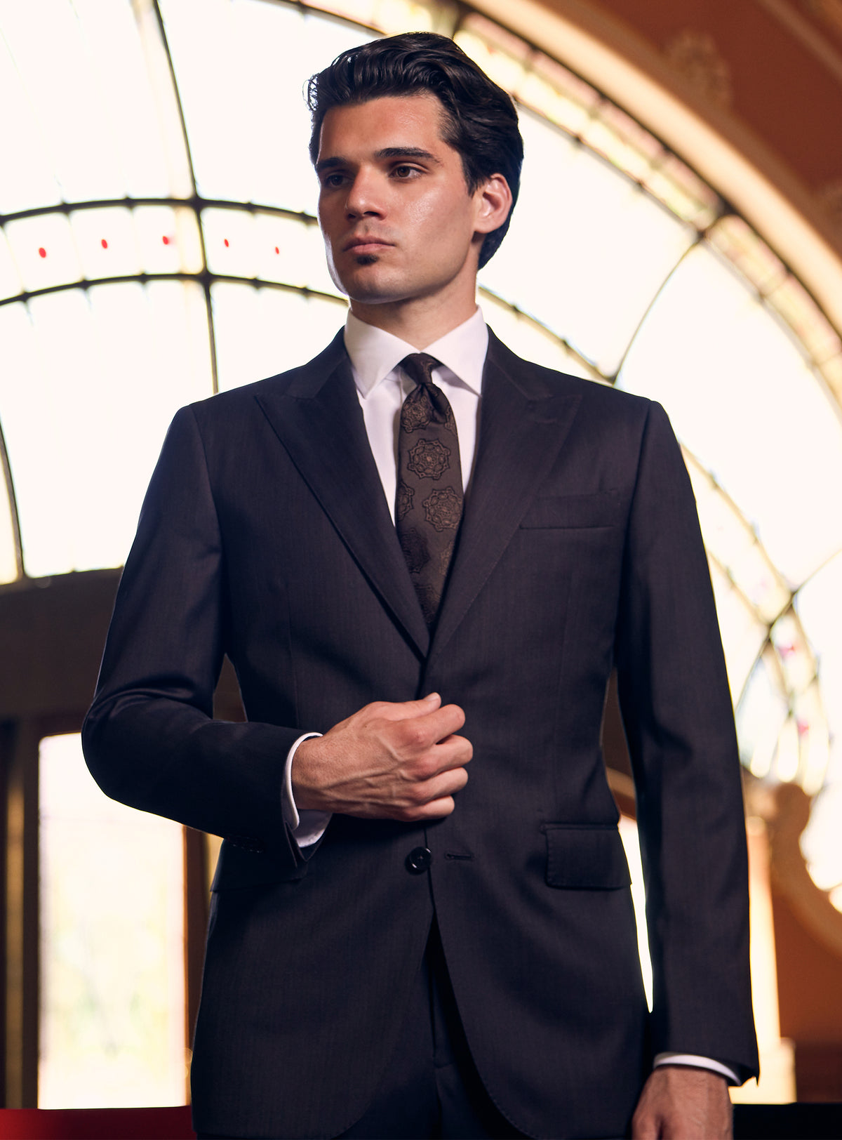 Charcoal Consiglieri suit with notch lapels, a white shirt and dark tie