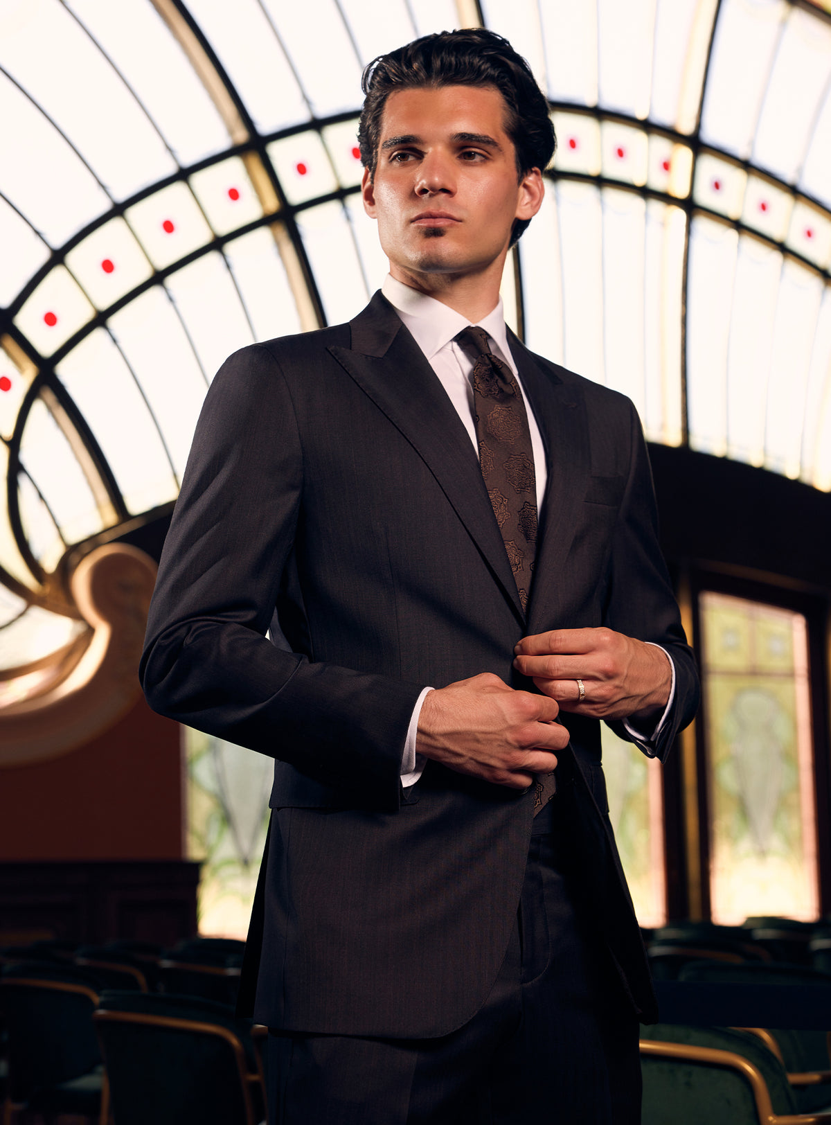 Charcoal Consiglieri suit with notch lapels, a white shirt and dark tie
