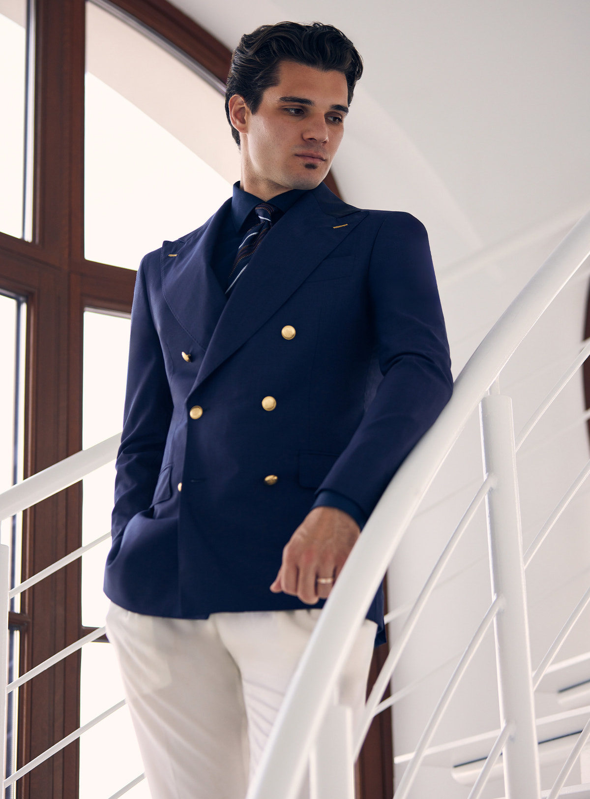 Navy double-breasted Consiglieri blazer with gold-tone buttons, worn with white trousers