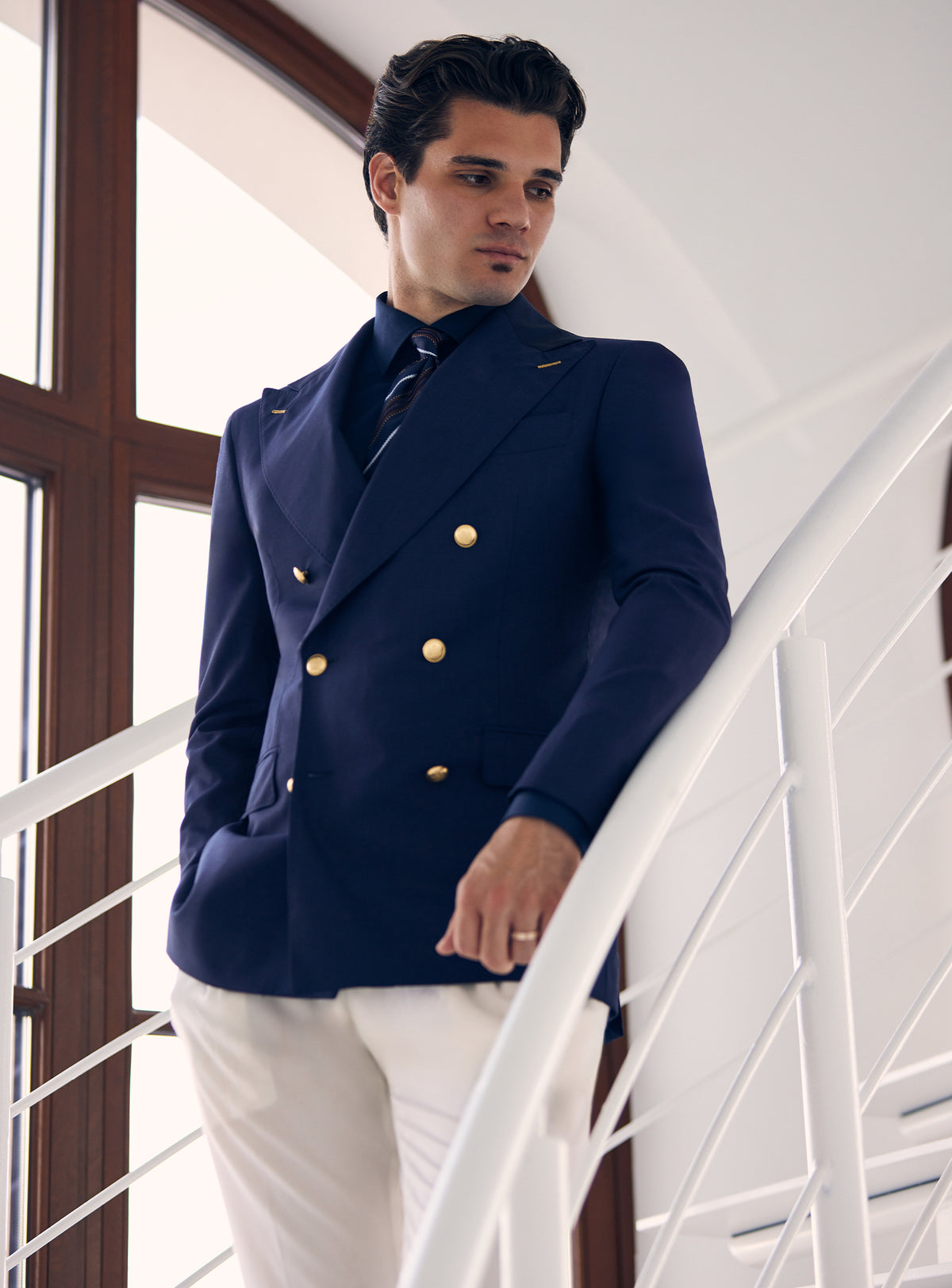 Navy double-breasted Consiglieri blazer with gold-tone buttons, worn with white trousers