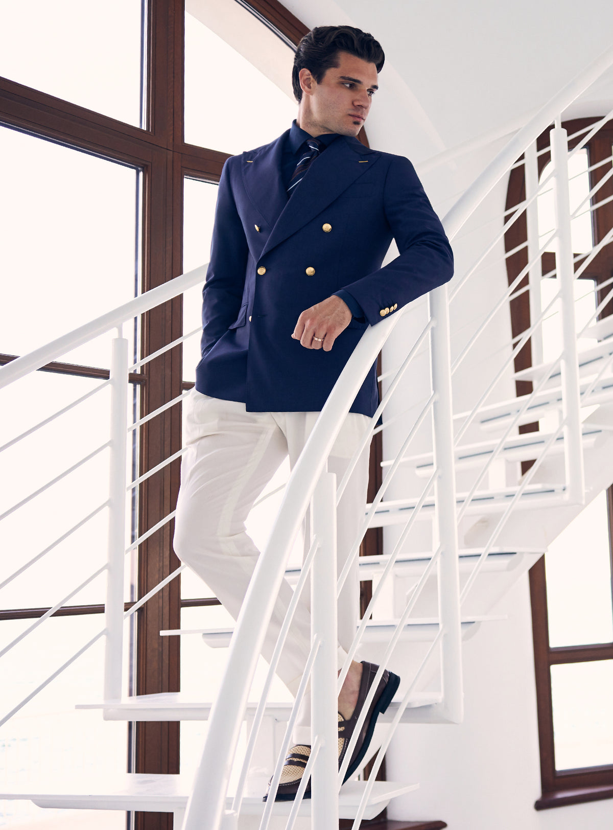Navy double-breasted Consiglieri blazer with gold-tone buttons, worn with white trousers