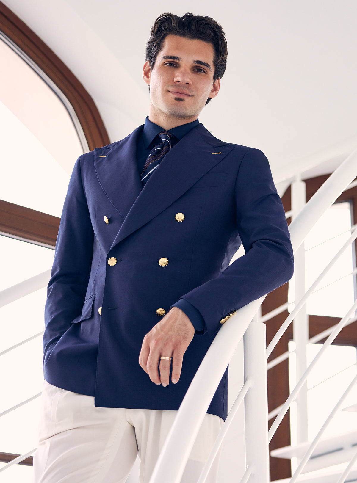 Navy double-breasted Consiglieri blazer with gold-tone buttons, worn with white trousers