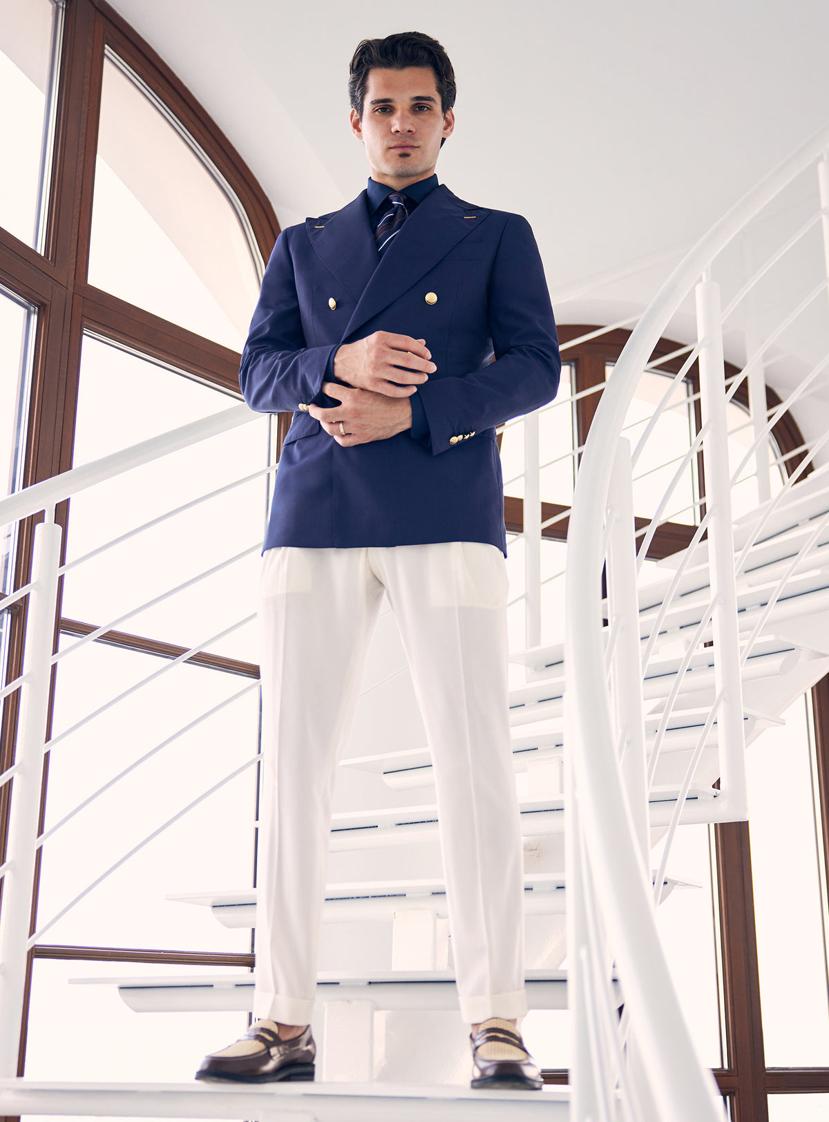 Navy double-breasted Consiglieri blazer with gold-tone buttons, worn with white trousers