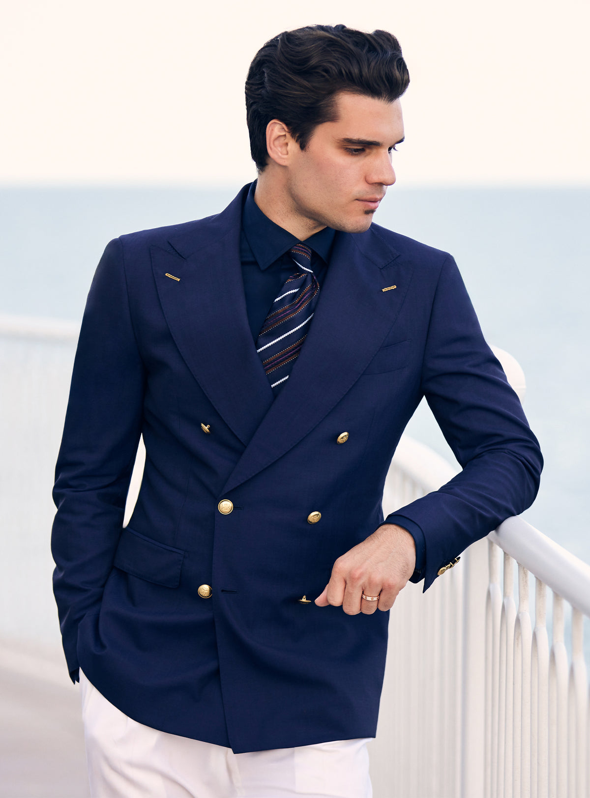 Navy double-breasted Consiglieri blazer with gold-tone buttons, worn with white trousers