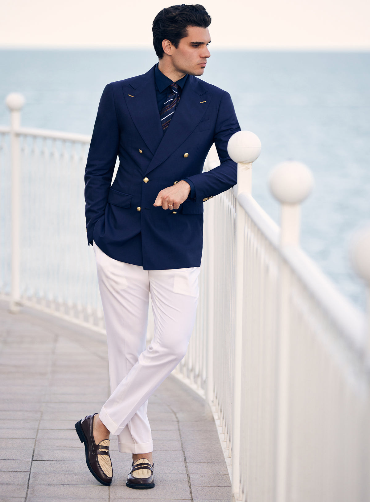 Navy double-breasted Consiglieri blazer with gold-tone buttons, worn with white trousers