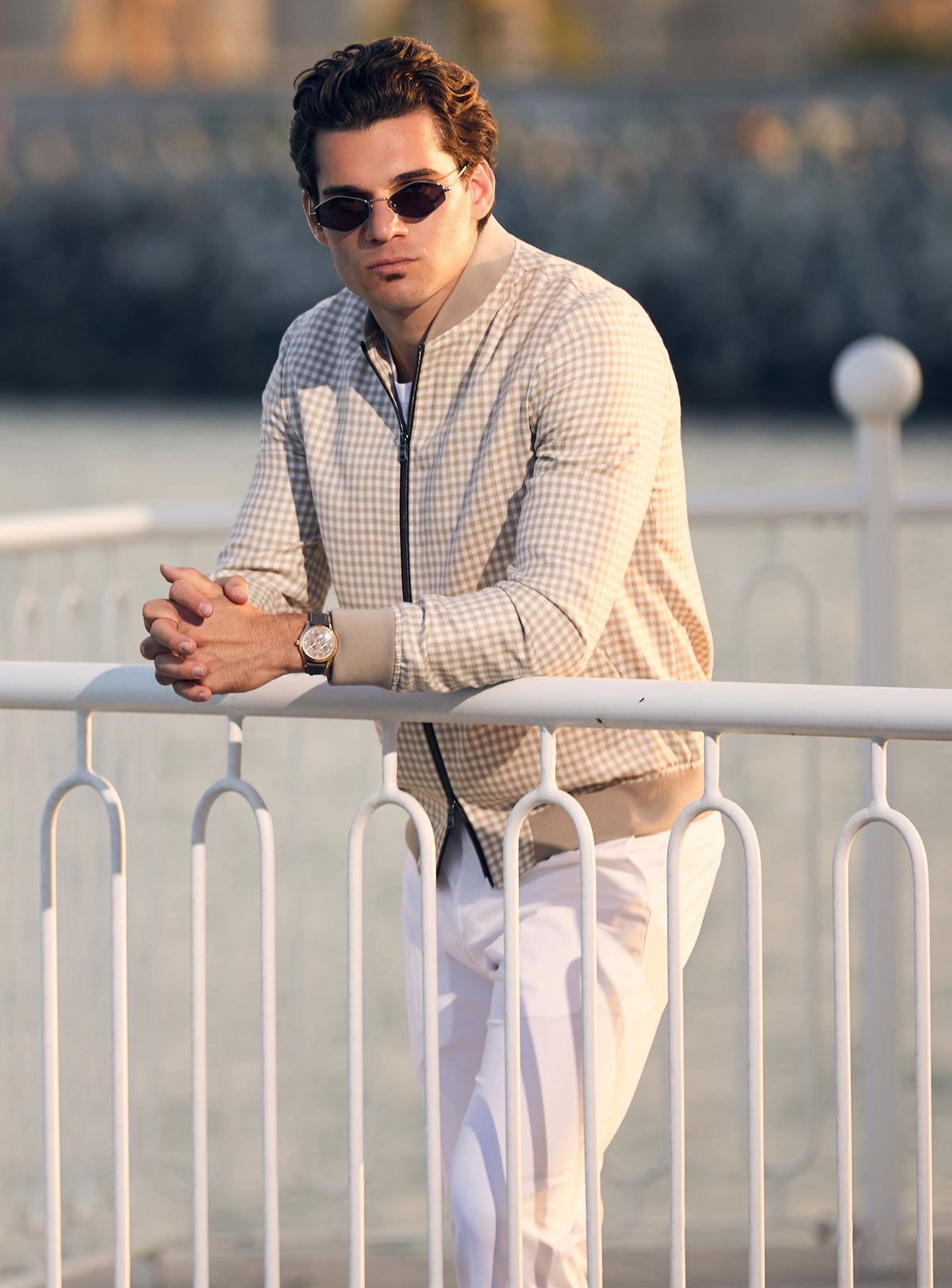 Beige Consiglieri bomber jacket with a subtle pattern and dark zip, worn with white trousers