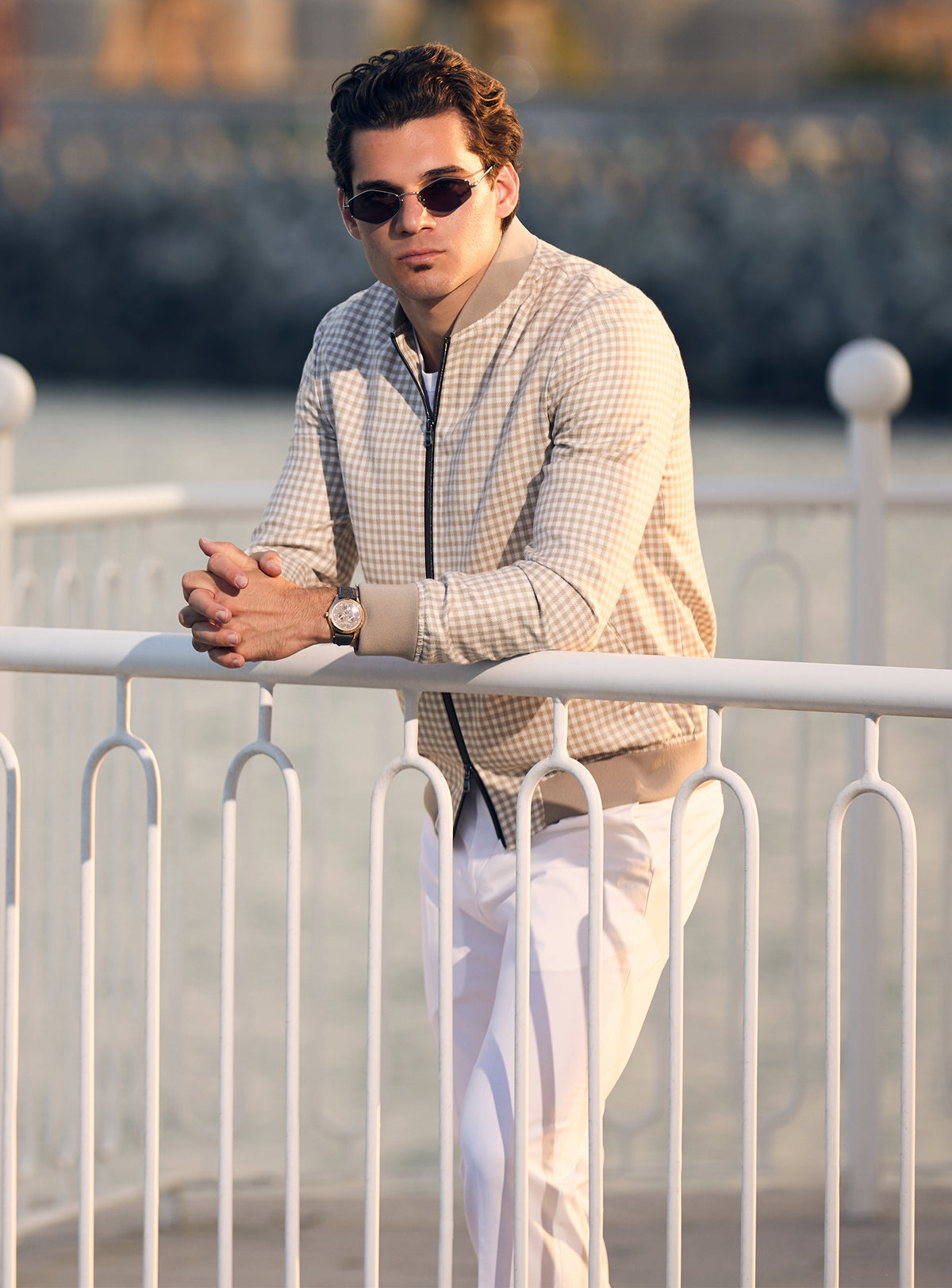 Beige Consiglieri bomber jacket with a subtle pattern and dark zip, worn with white trousers