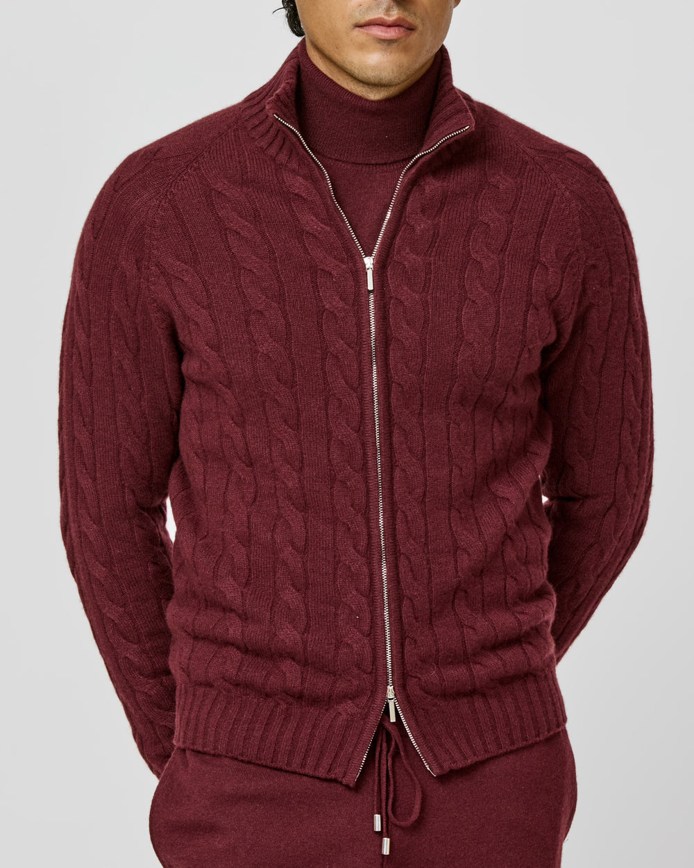 Burgundy cable-knit Consiglieri zip cardigan layered over a matching turtleneck