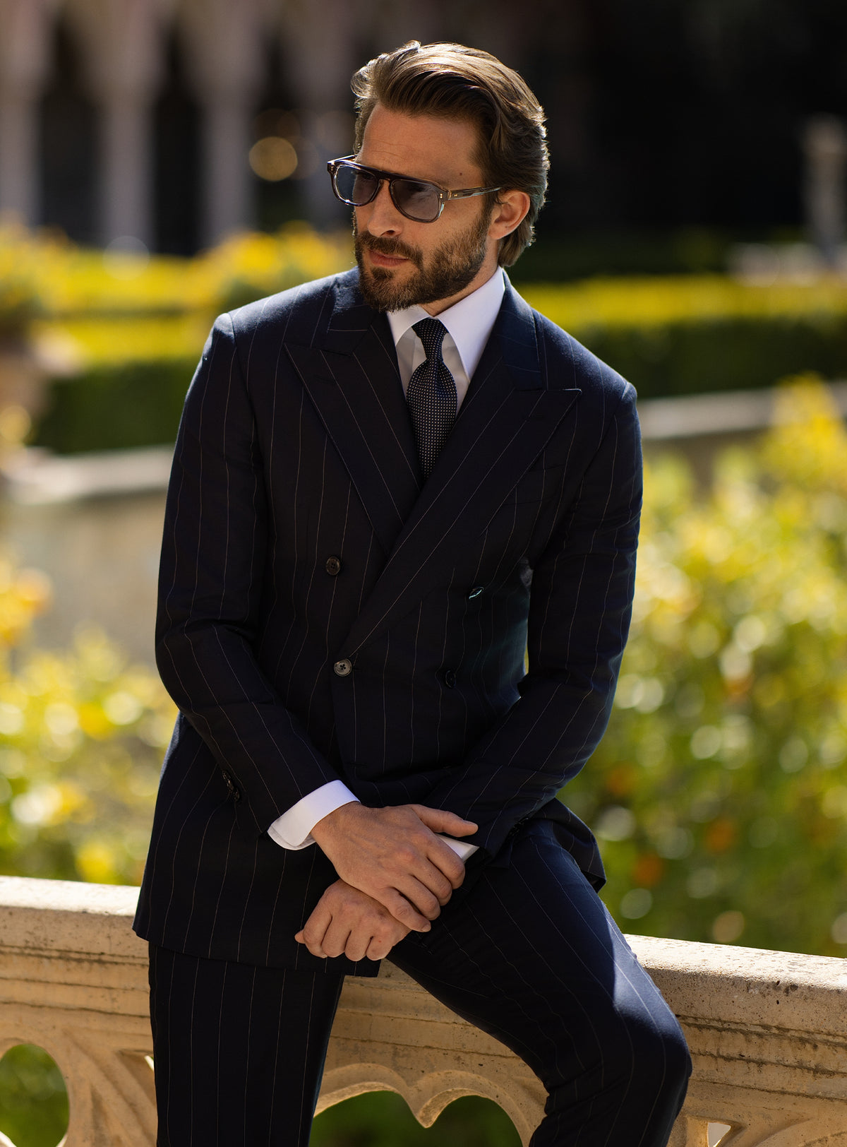 Navy pinstriped double-breasted Consiglieri suit worn with a dark tie