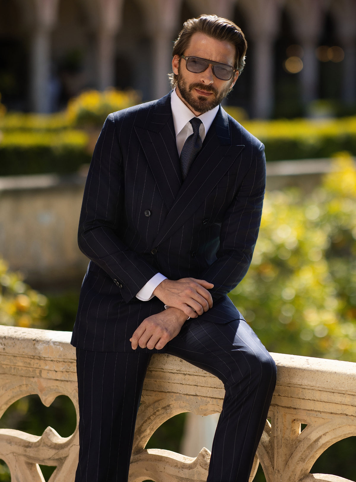 Navy pinstriped double-breasted Consiglieri suit worn with a dark tie