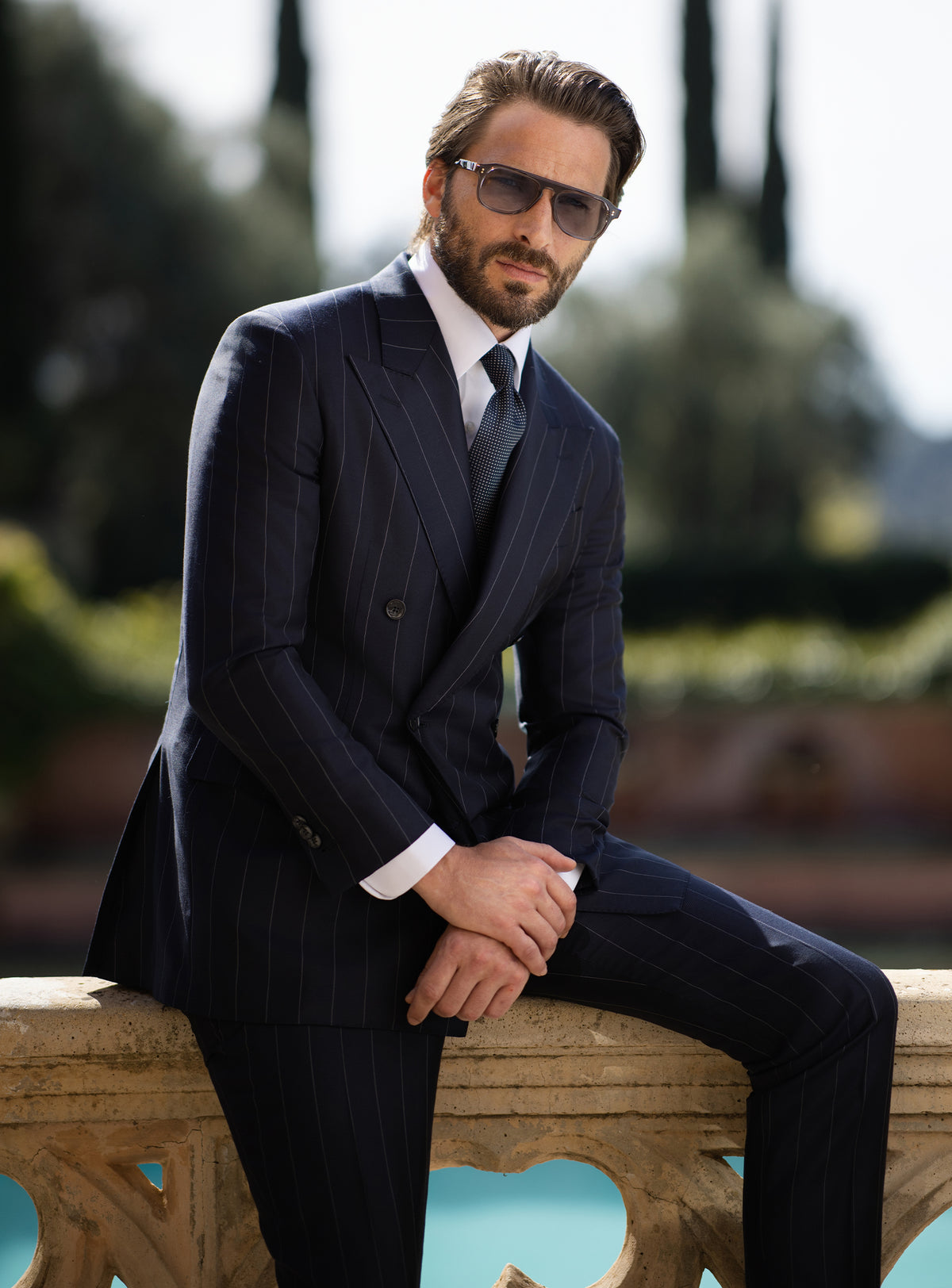 Navy pinstriped double-breasted Consiglieri suit worn with a dark tie