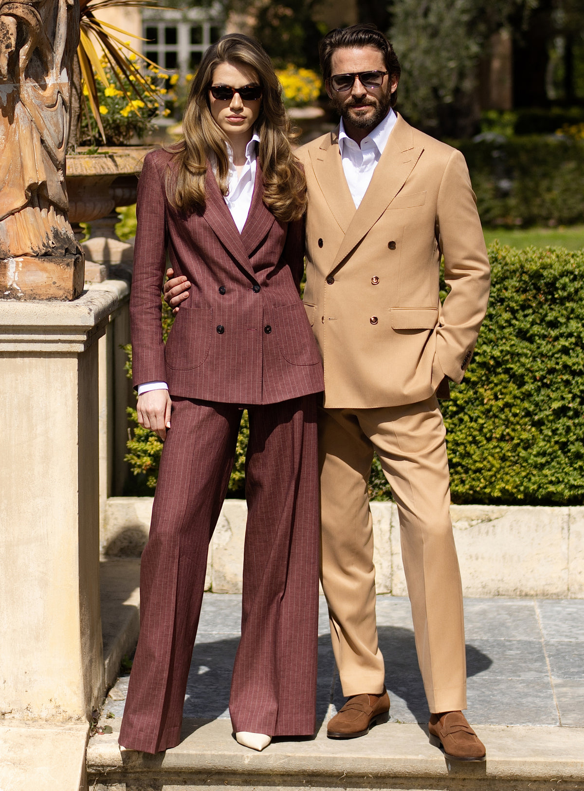 Camel men's suit and burgundy women's suit by Consiglieri, styled as a couple