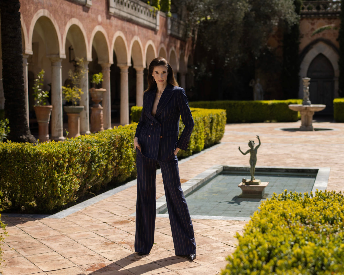 Women's navy suit with wide-leg trousers beside a fountain
