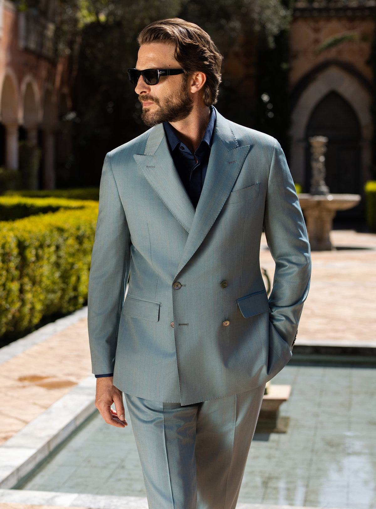 Blue-grey double-breasted Consiglieri suit worn with a dark shirt
