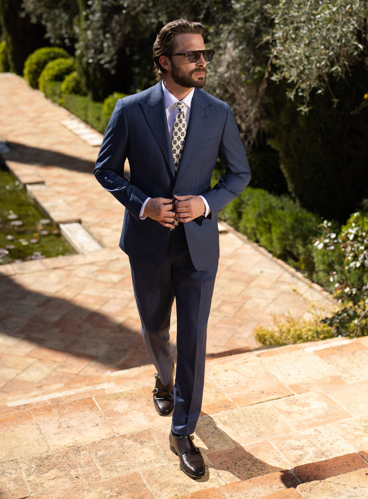 Navy Consiglieri suit with notch lapels, worn with a light patterned tie