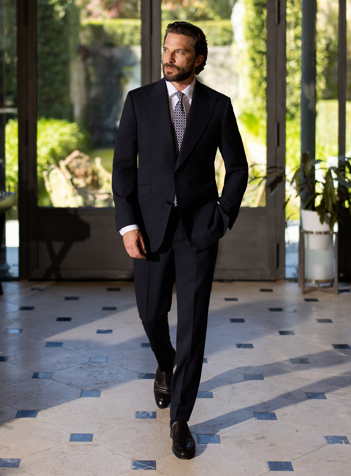 Deep navy Consiglieri suit worn with a white shirt and patterned tie
