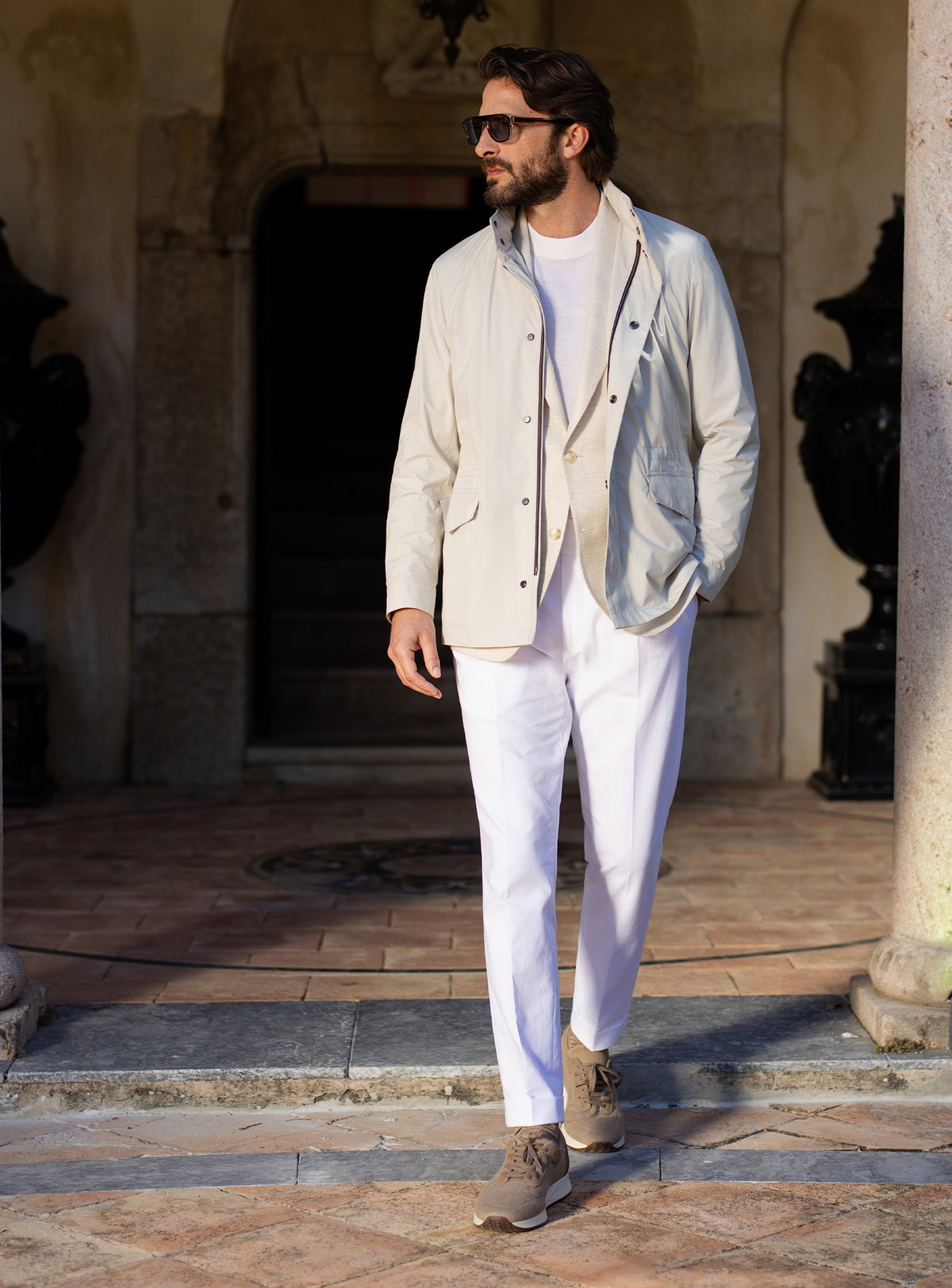 Light grey Consiglieri four-pocket jacket worn with a white T-shirt and white trousers
