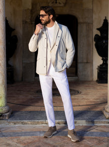 Light grey Consiglieri four-pocket jacket worn with a white T-shirt and white trousers