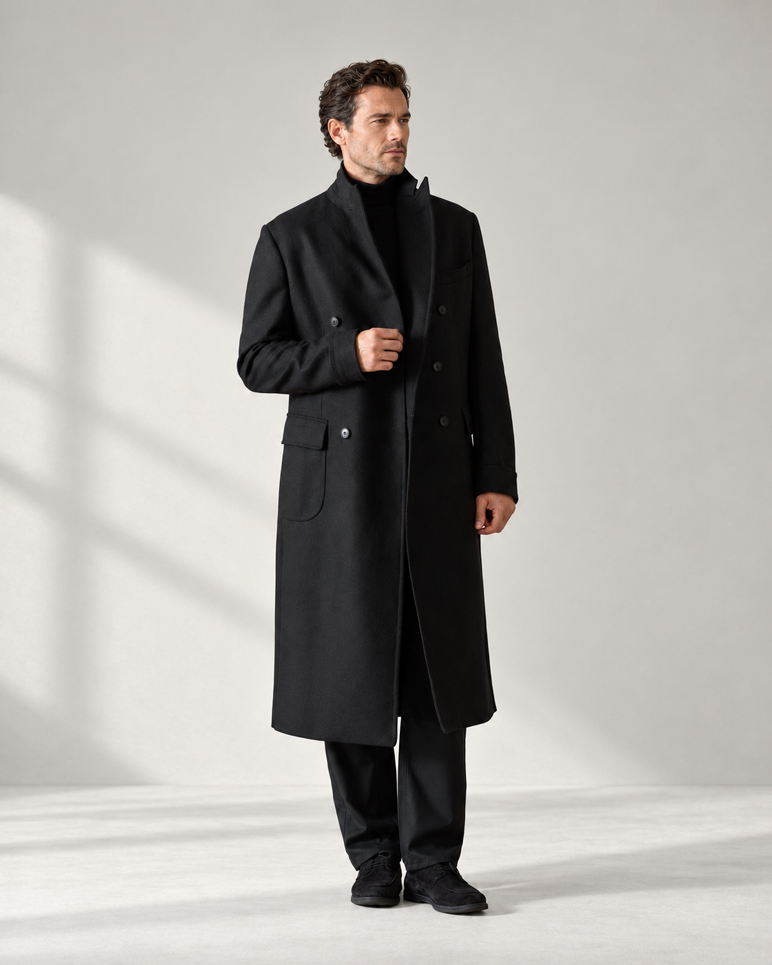 Black coat over a black roll-neck and dark trousers