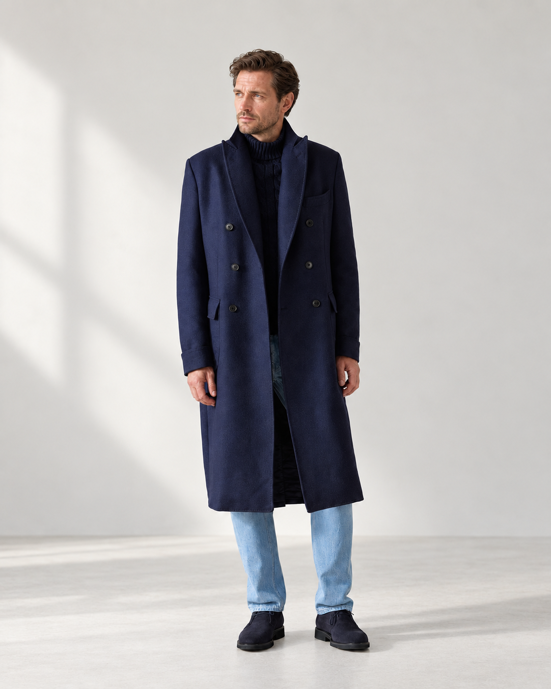Navy coat with a dark roll-neck and light blue jeans