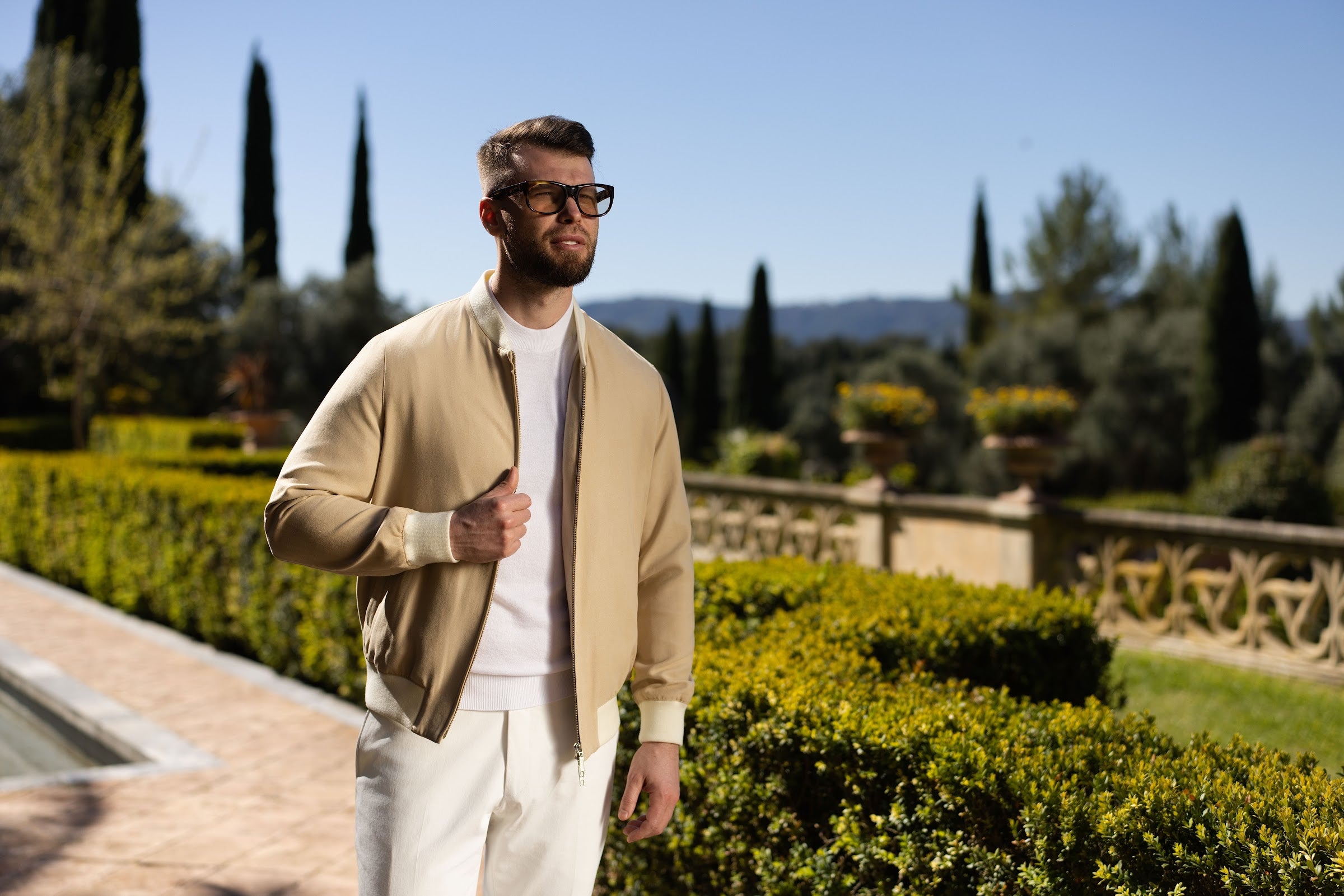 The sand Bomber Jacket in a panoramic composition that highlights its clean silhouette.