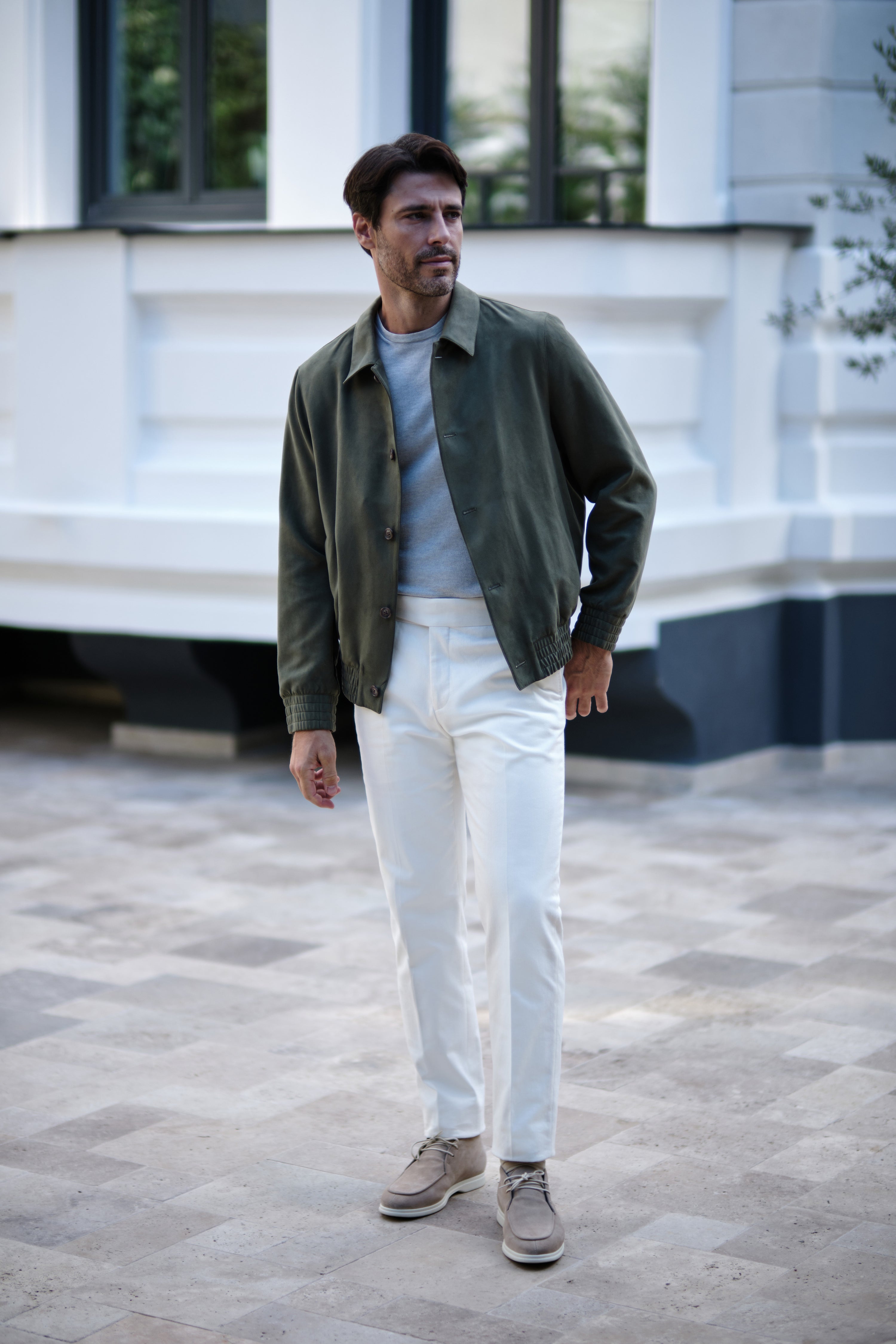 Complete Consiglieri look with an olive blouson, light grey top and white trousers