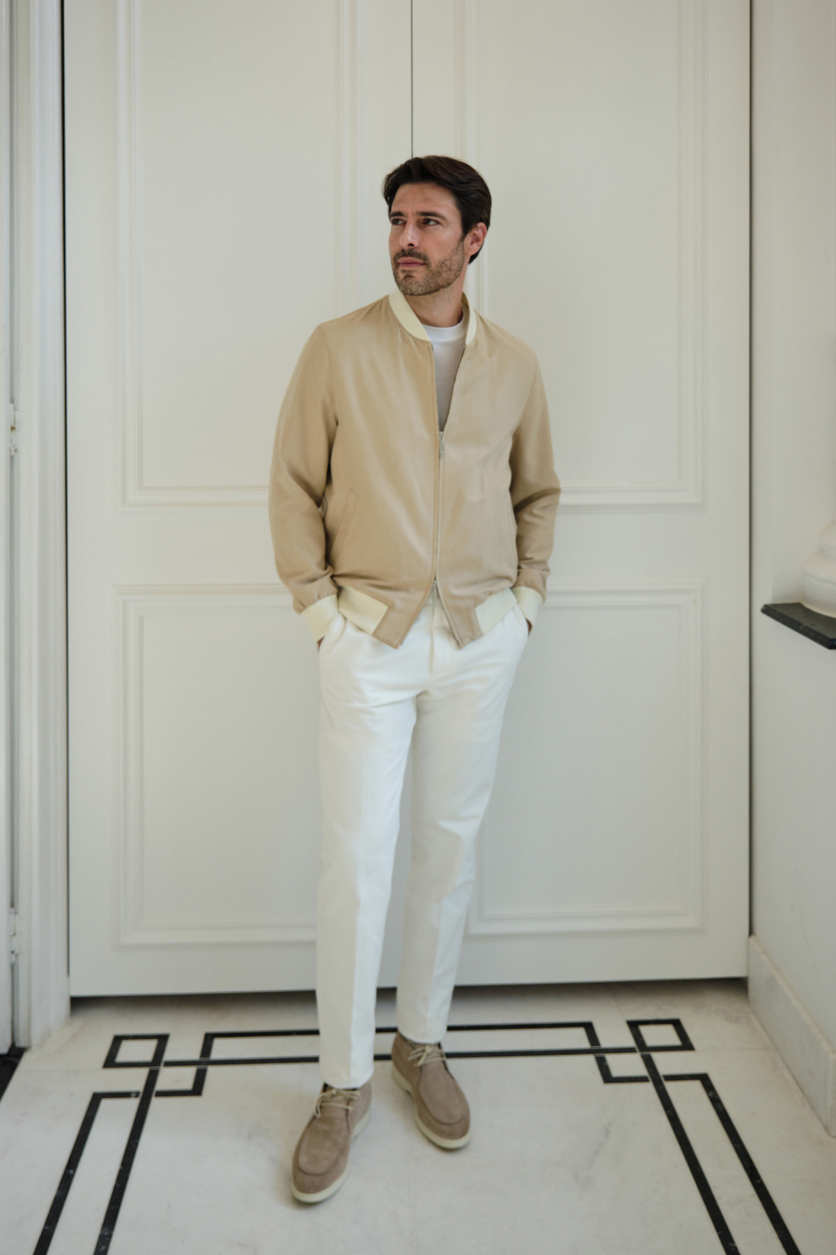 Beige Consiglieri bomber jacket worn with white trousers