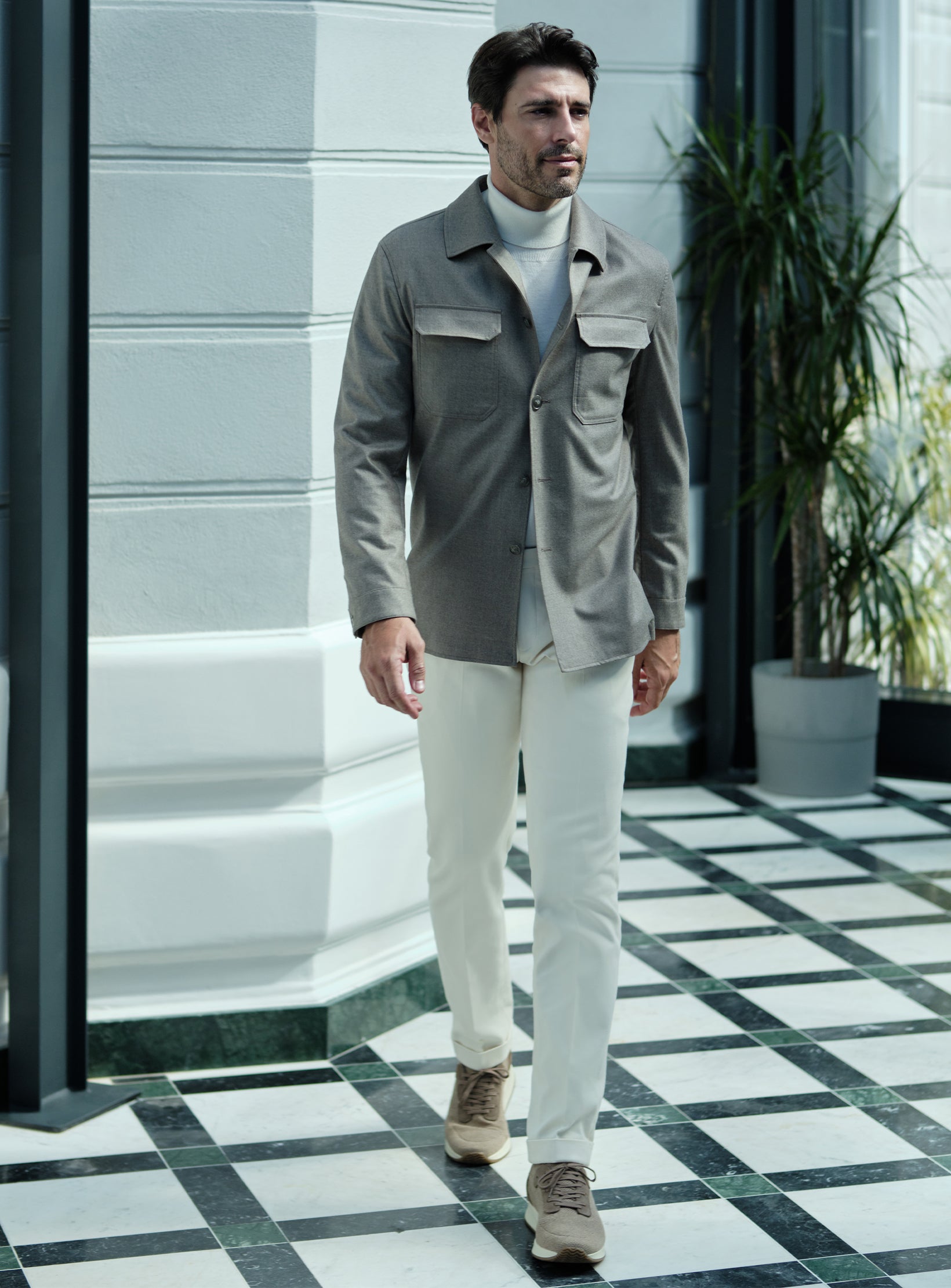Jachetă tip cămașă gri, pulover alb pe gât, pantaloni Ivory și pantofi sport taupe