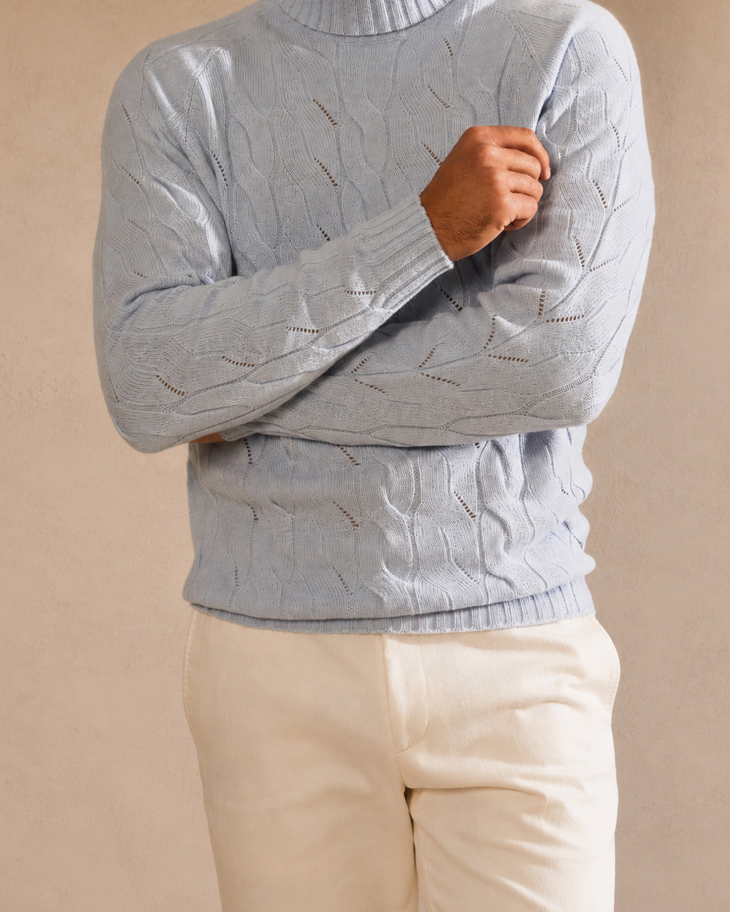 Pale-blue cable-knit sweater with a high collar and finely worked texture.