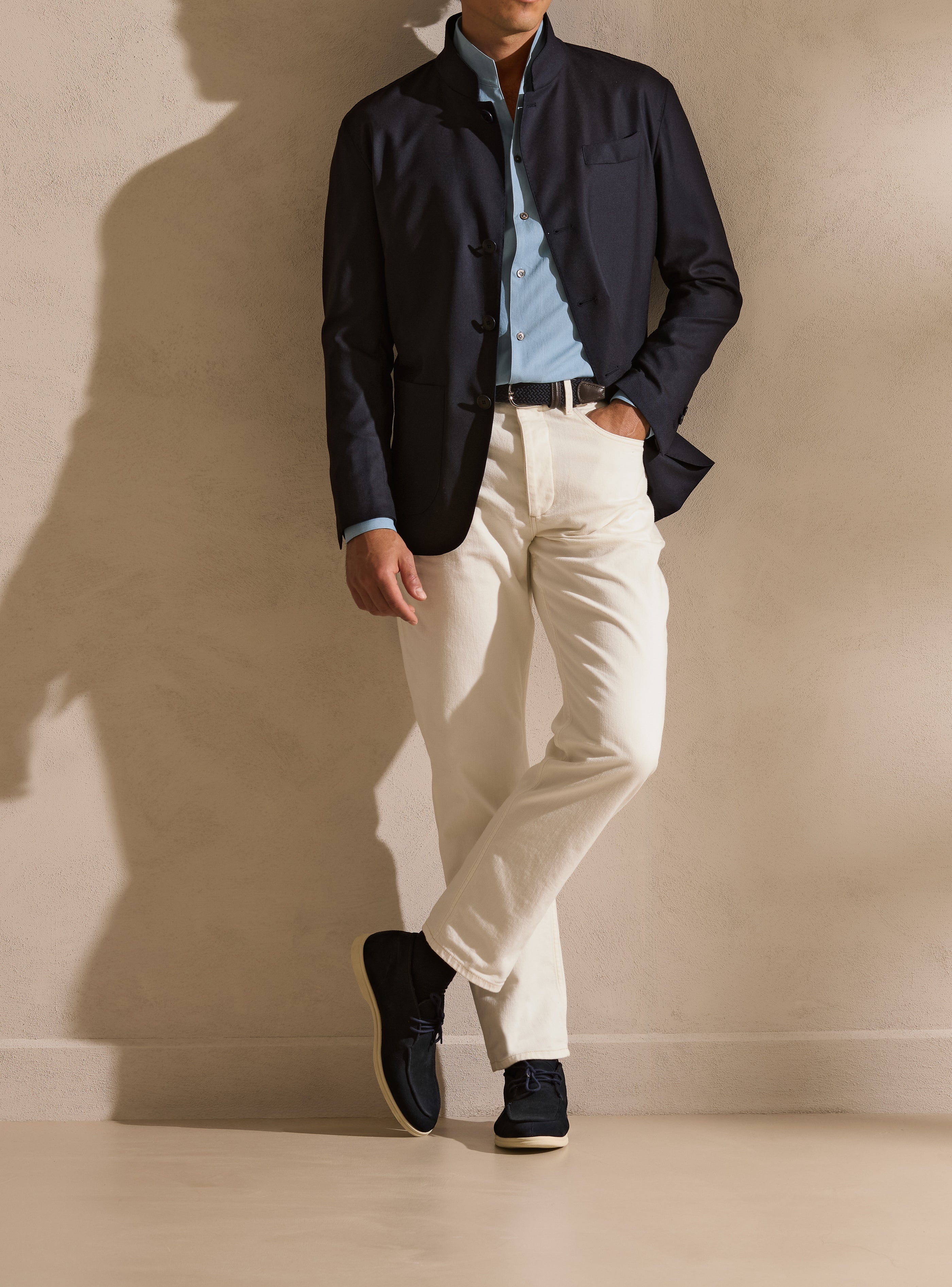 Navy Mao-collar jacket balanced by light trousers — a quiet opening note of the Pre-Fall wardrobe.