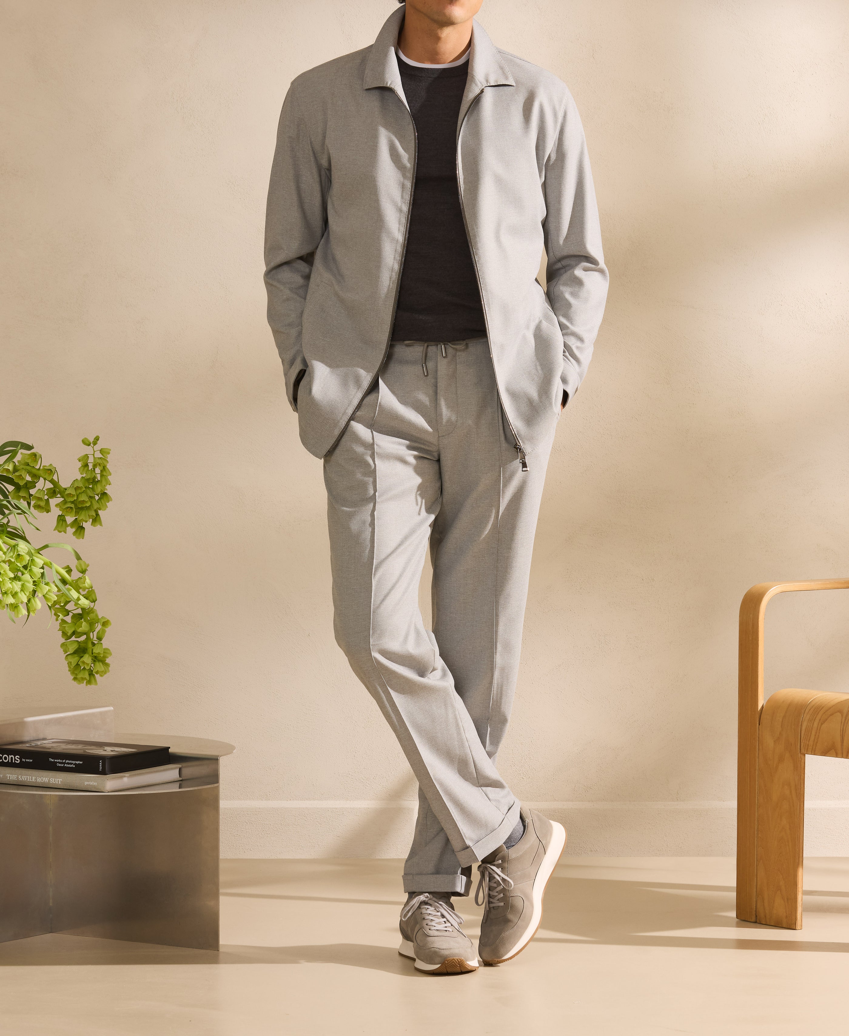 A light grey jacket worn with runners — an easy reading of early autumn.
