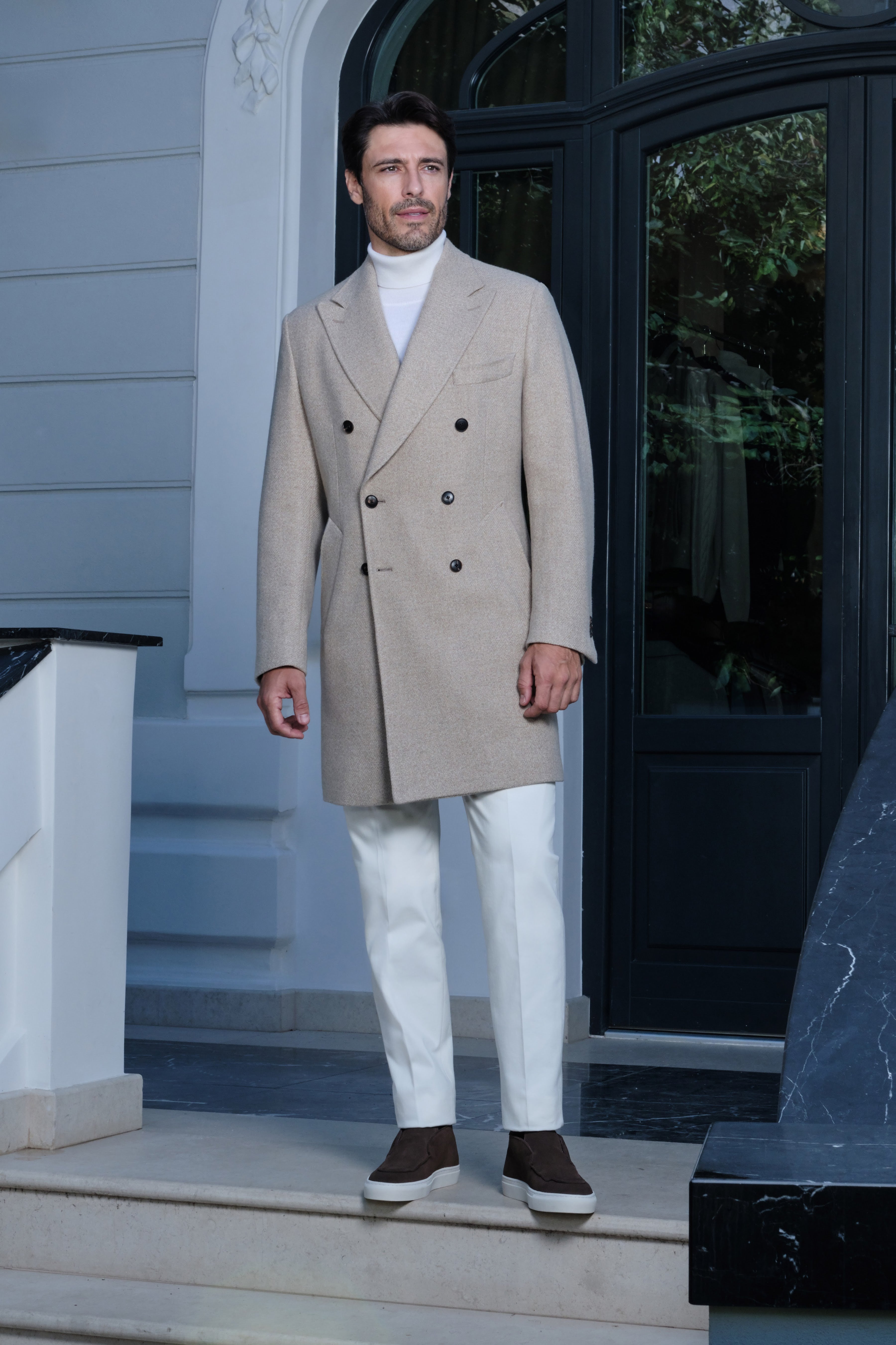 The Overcoat in motion, framed by architecture that accentuates its silhouette.