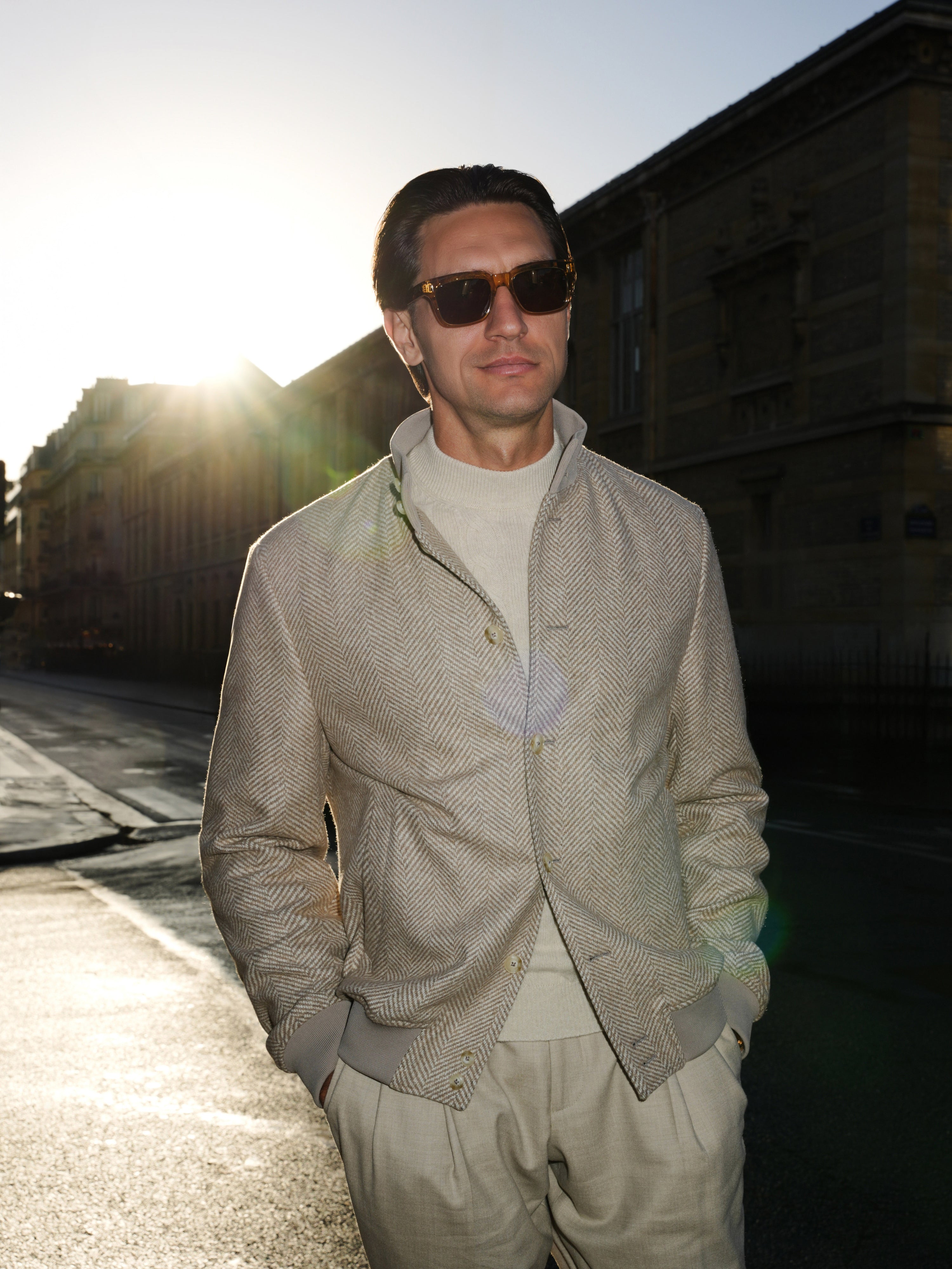 Detail of a grey-beige textured blouson, worn with knitwear and trousers in light tones