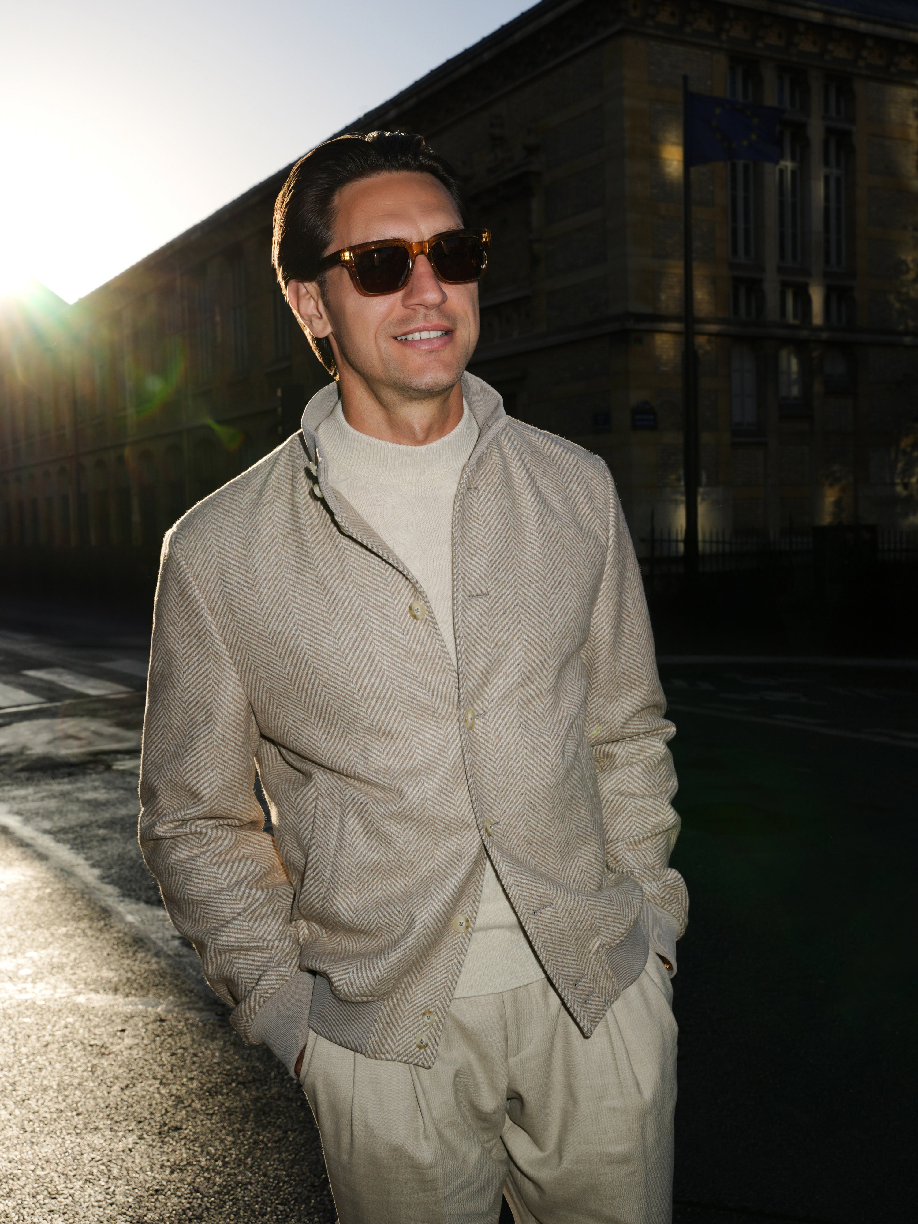 Textured blouson in grey-beige tones, photographed in urban light