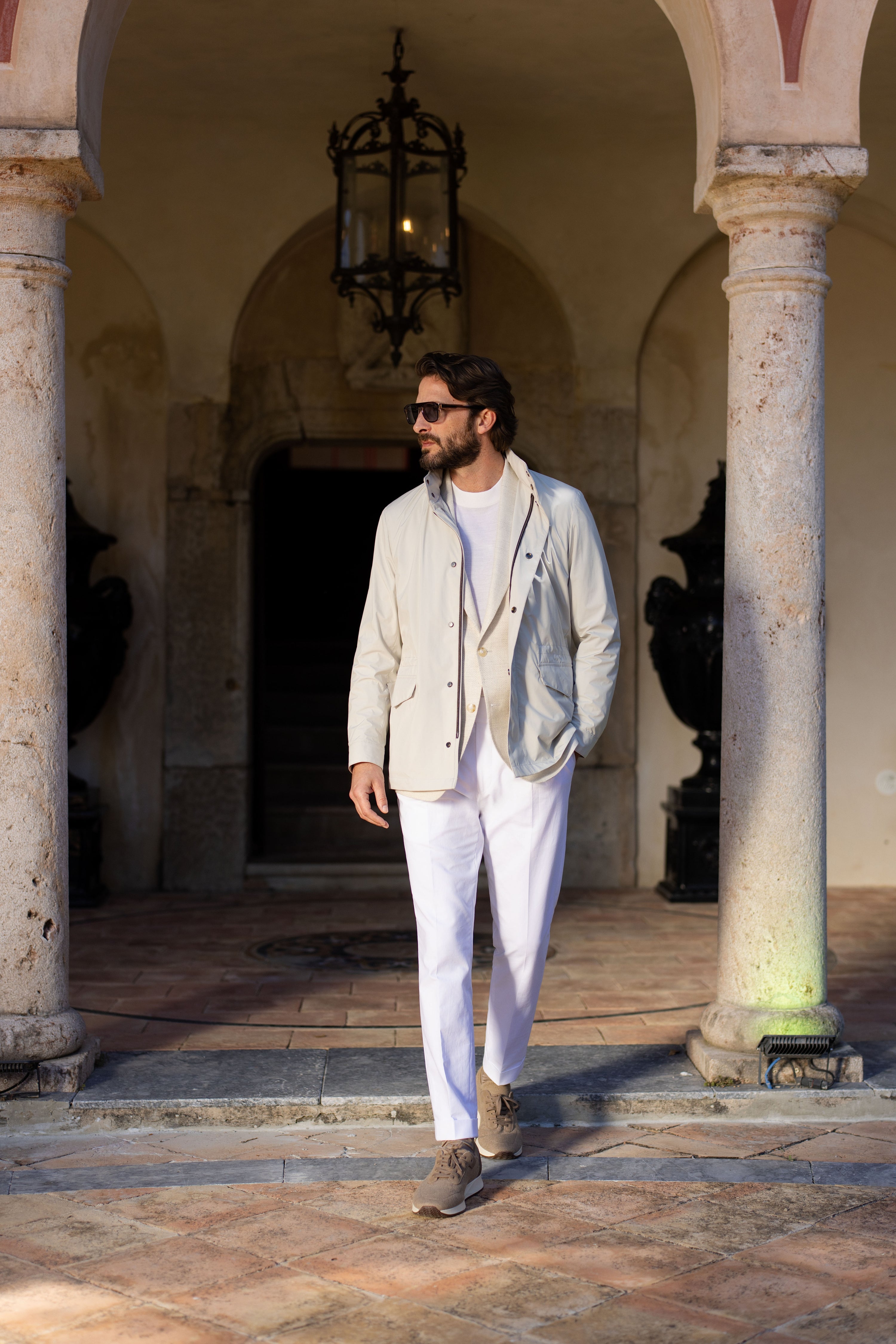 Consiglieri outfit with a light-coloured blouson, photographed beside a colonnade