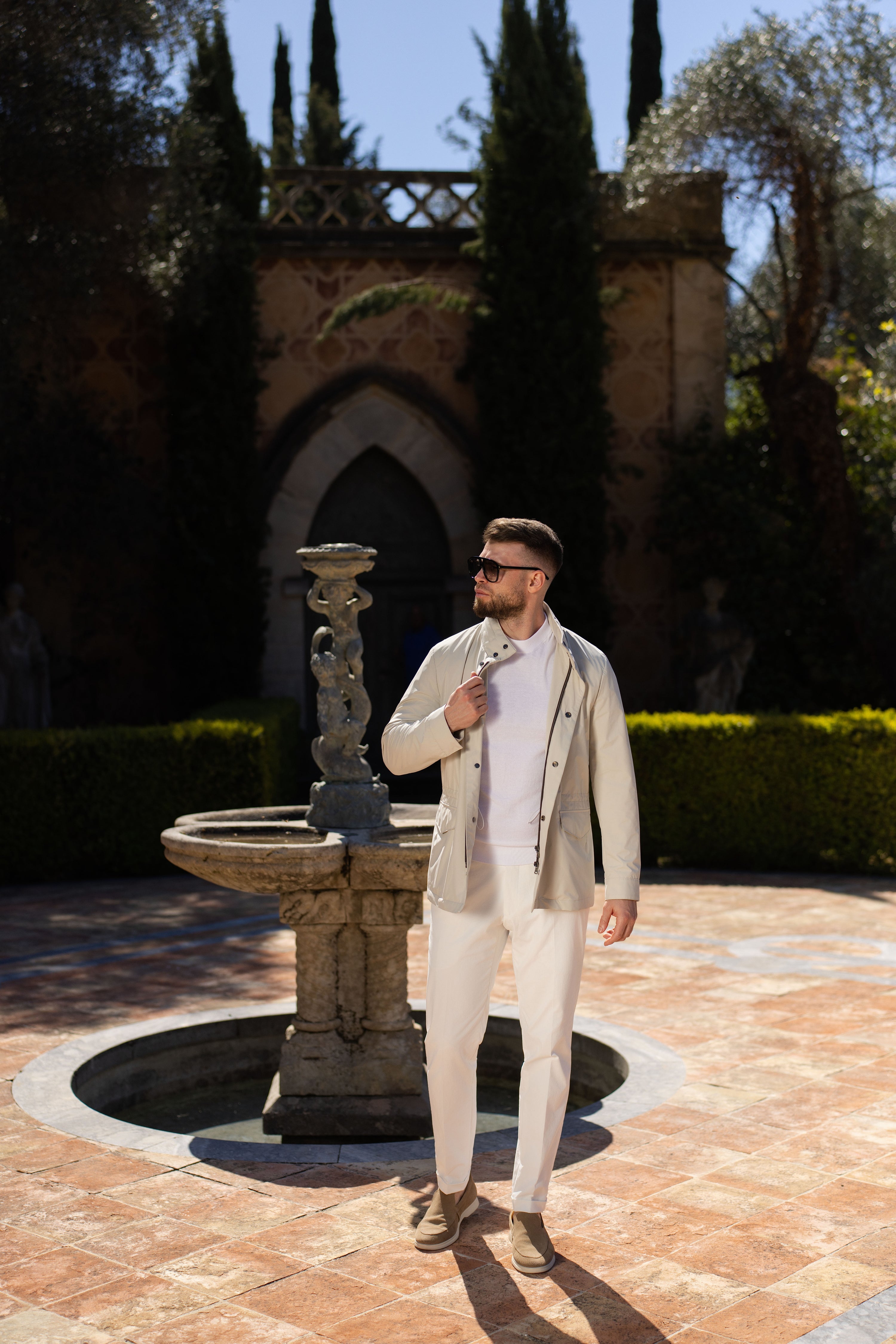 Consiglieri outfit with a light-coloured blouson, photographed beside a fountain